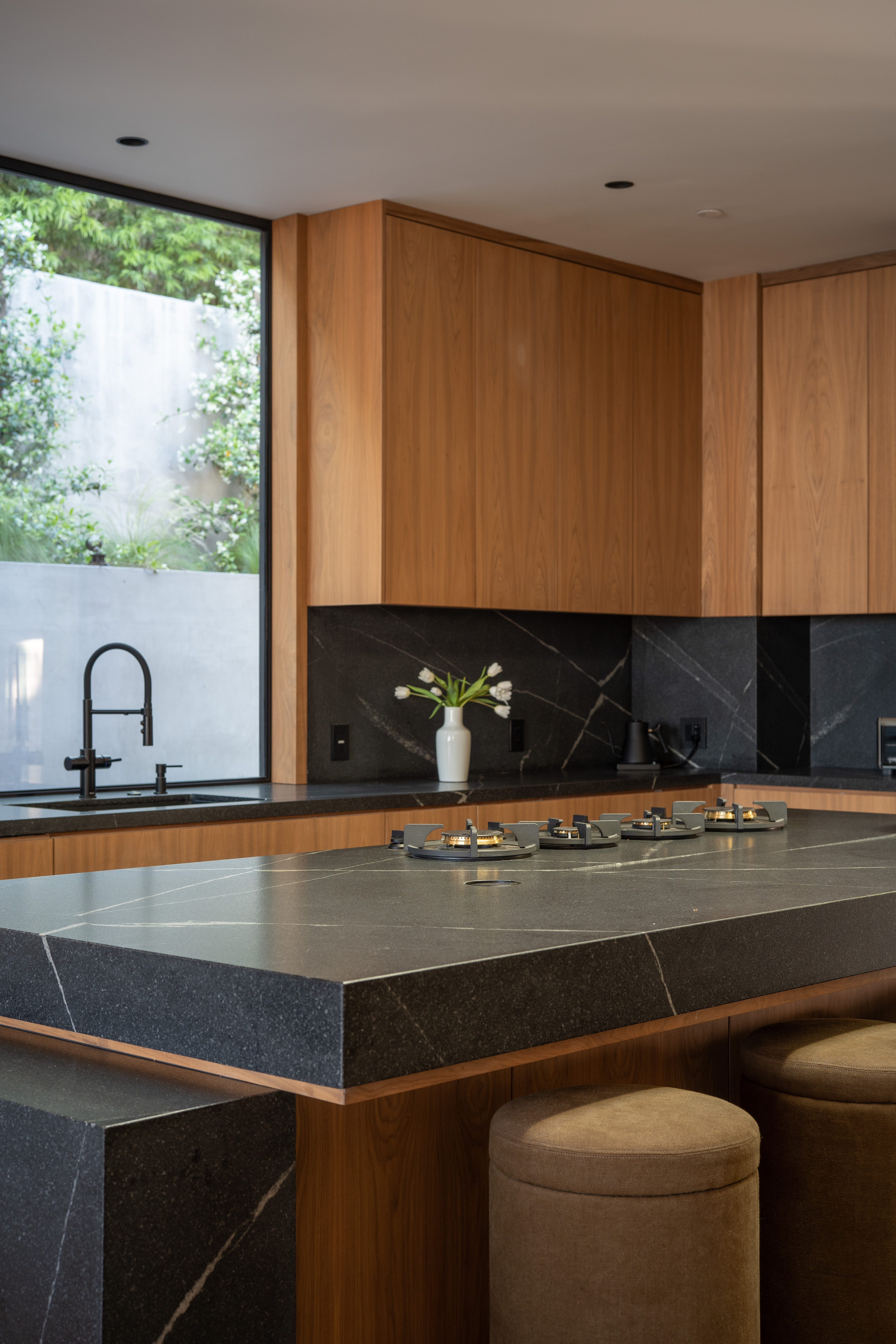 Kitchen — walnut cabinetry, black stone island
