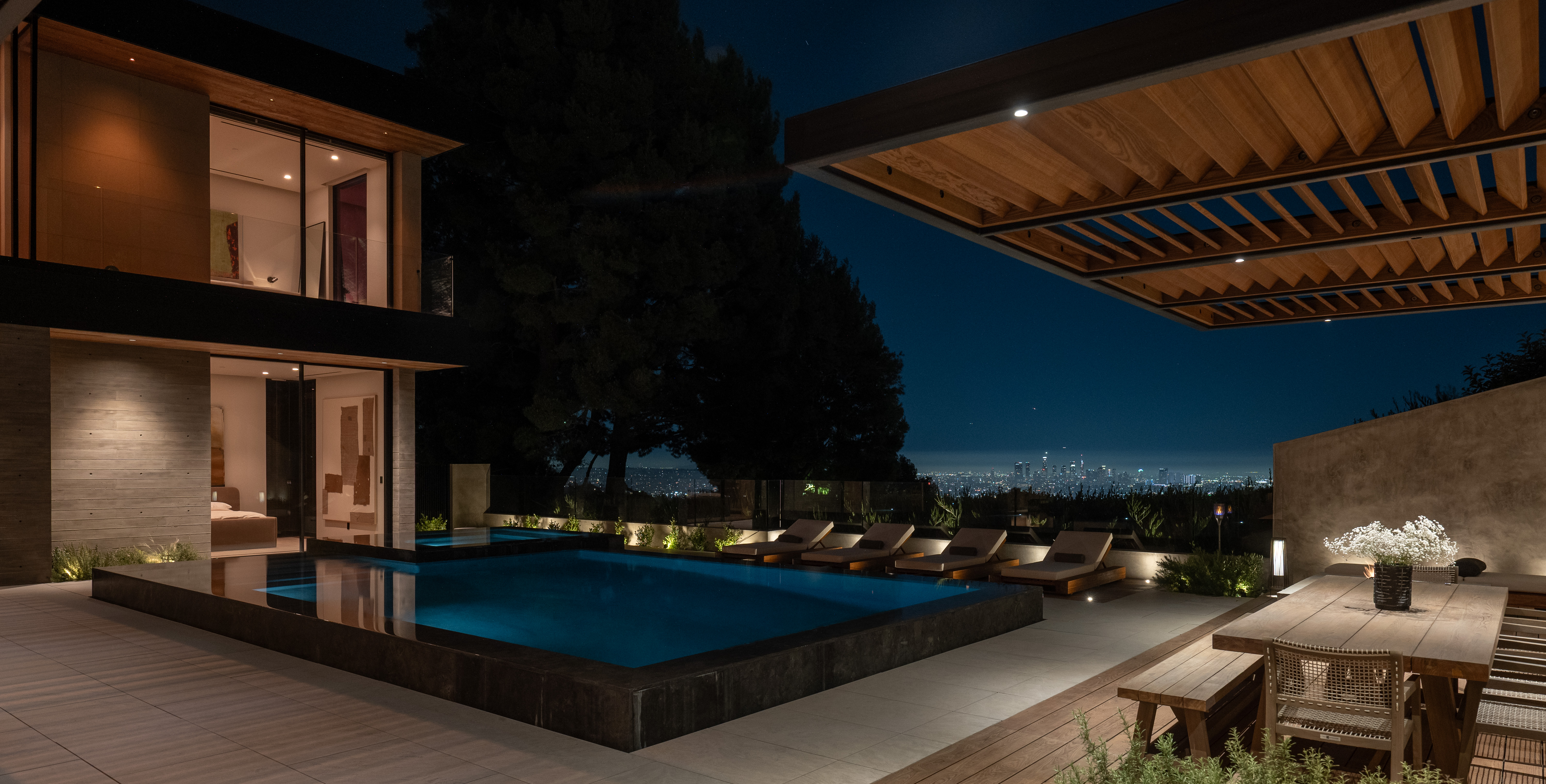 Pool terrace at night — Los Angeles skyline beyond